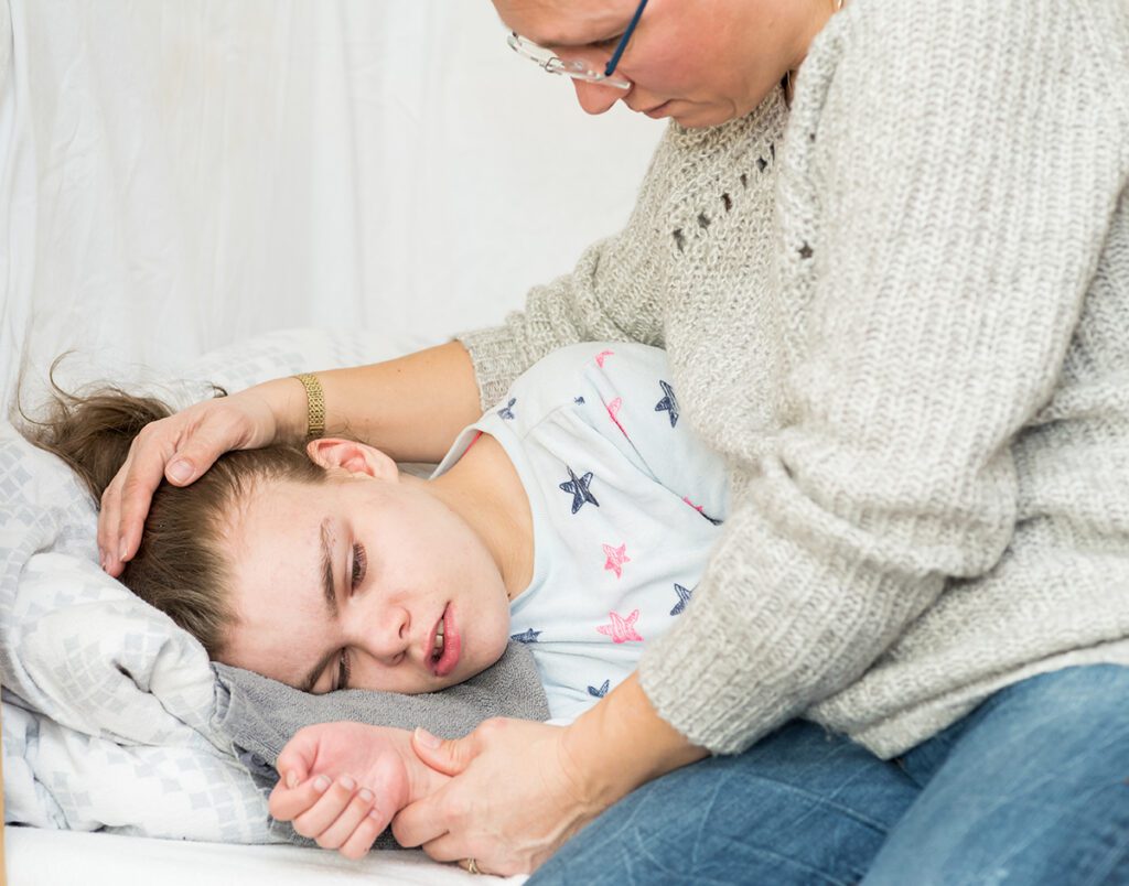 A child being cared for during an epileptic seizure by a qualified special needs carer